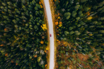 Red car traveling through colorful fall foliage